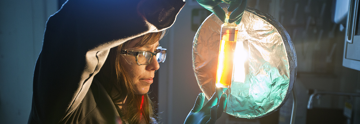 Women holding up lubricant sample in laboratory.