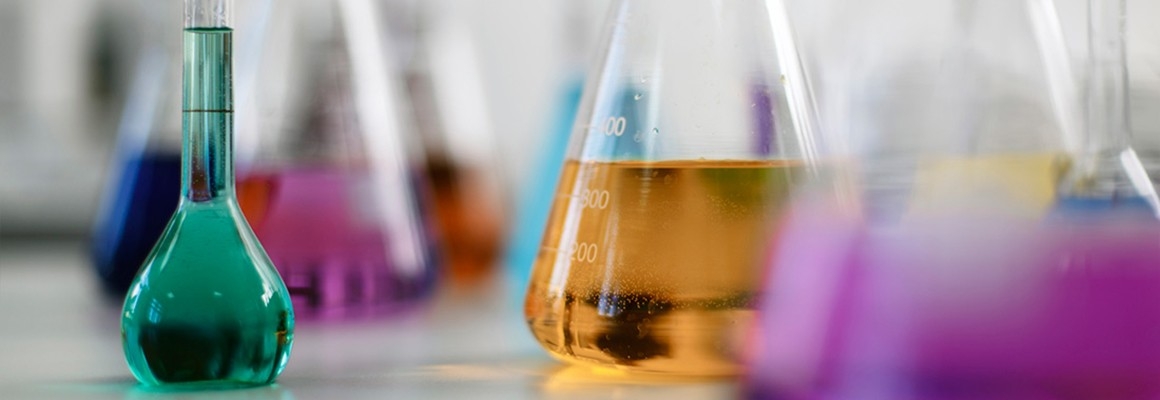 Close-up of colorful chemicals in laboratory glassware.