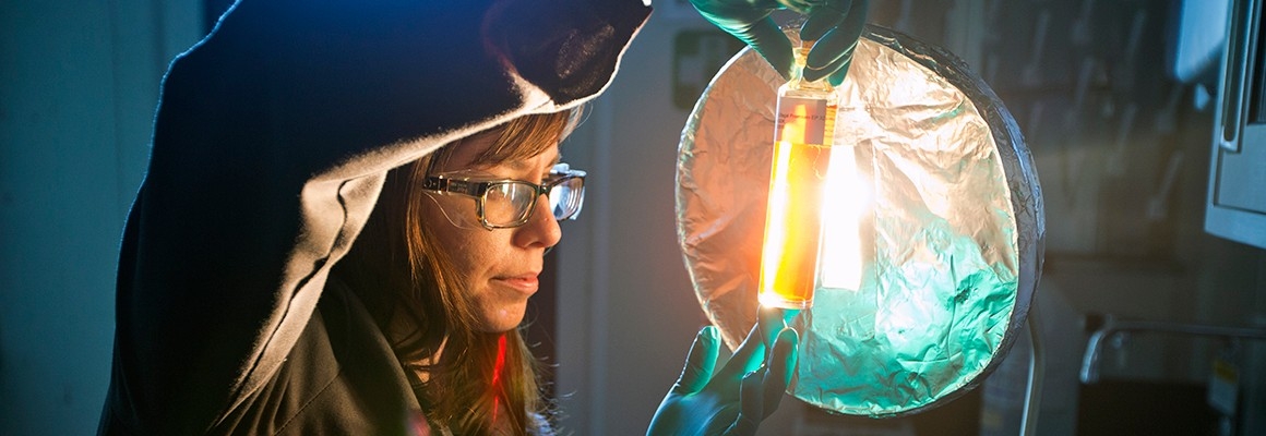 Women holding up lubricant sample in laboratory.